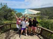 Group of travellers at North Gorge Walk with North Stradbroke Island beach backdrop