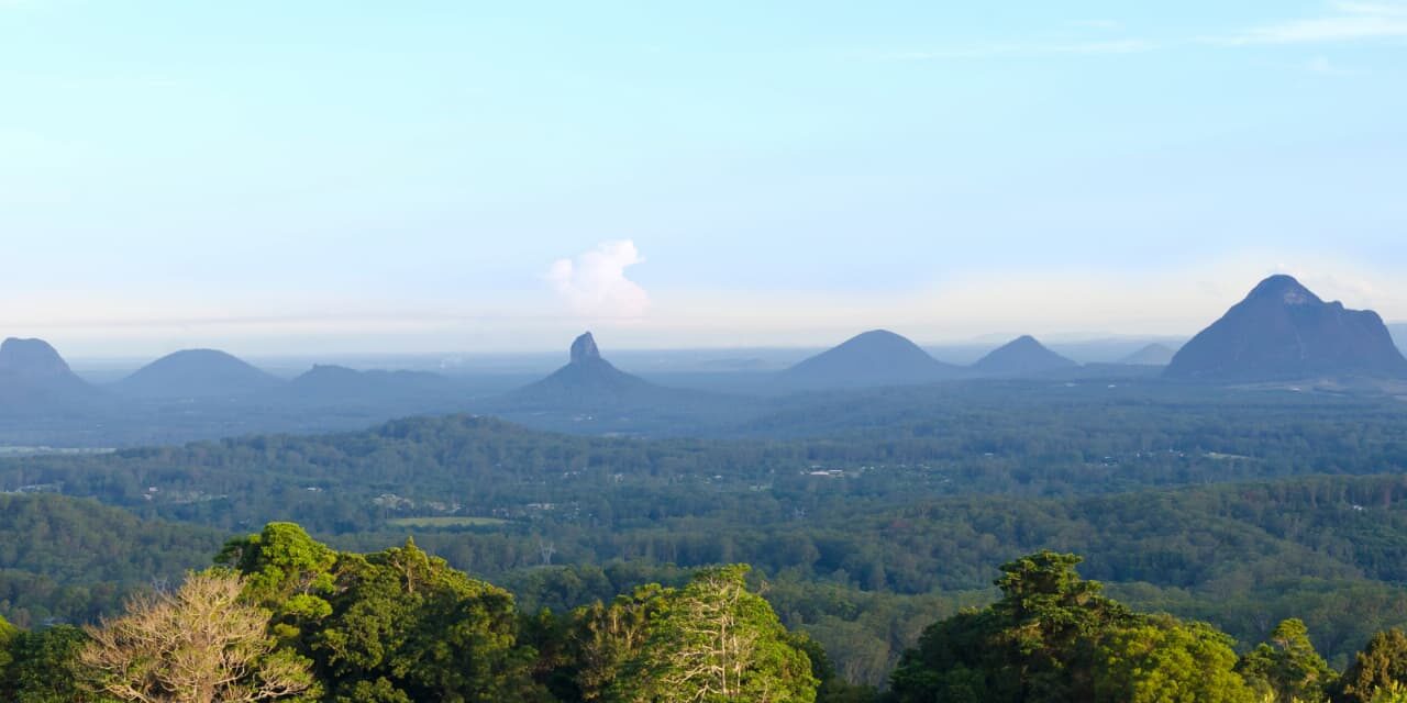 sunshine-coat-with-adt-9 Scenic view of the Glass House Mountains on the Sunshine Coast Queensland with lush forest and clear blue sky